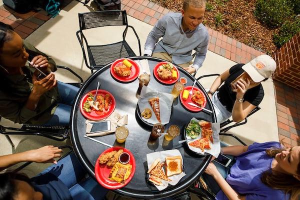 学生 eat and chat outside at Fresh Food Company